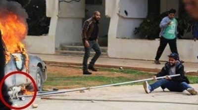 صورة اليوم : شاب ليبي يخاطر بحياته لانقاذ قطة من تحت سيارة مشتعلة في بنغازي