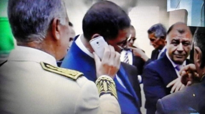 صورة: والي تونس يمسك الهاتف الجوال للحبيب الصيد وهو يتحدث